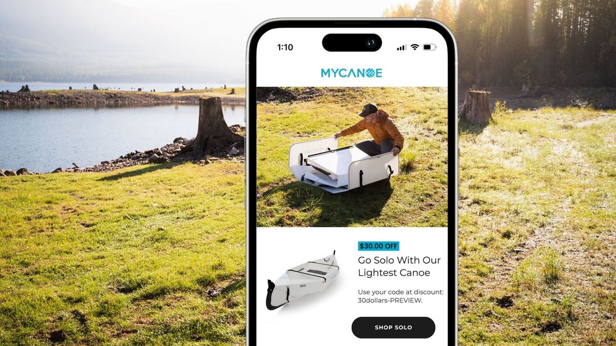 MyCanoe website on a phone, set against a lakeside with the folding canoe